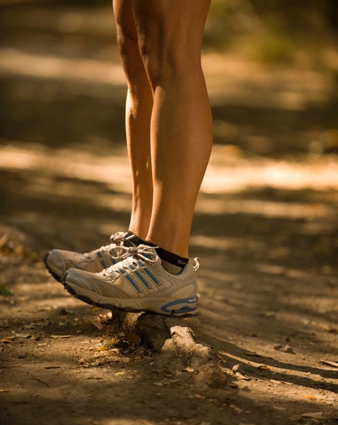 Person balancing on tree root in running shoes
